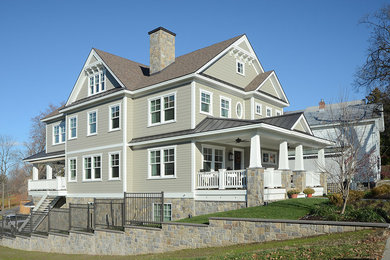Foto de fachada de casa beige de estilo americano grande a niveles con revestimiento de vinilo, tejado a cuatro aguas y tejado de teja de madera