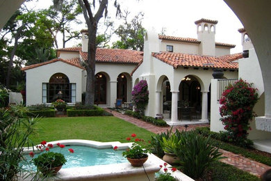 Стильный дизайн: большой, двухэтажный, белый дом в средиземноморском стиле с облицовкой из цементной штукатурки и вальмовой крышей - последний тренд