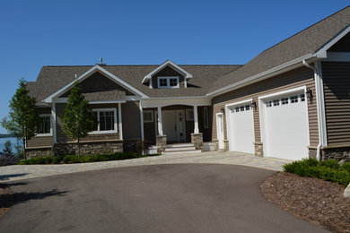 Cette photo montre une façade de maison marron chic de taille moyenne et de plain-pied avec un revêtement mixte, un toit à deux pans et un toit en shingle.