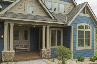 Immagine della facciata di una casa grande blu classica a due piani con rivestimento in legno e tetto a capanna