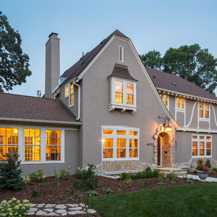 Example of a classic gray two-story exterior home design in Minneapolis with a clipped gable roof
