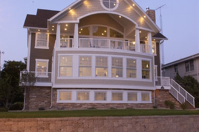 Diseño de fachada de casa beige clásica grande de tres plantas con tejado de un solo tendido y tejado de teja de madera
