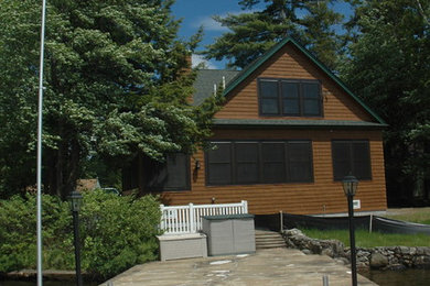 Inspiration for a mid-sized timeless brown two-story vinyl exterior home remodel in Manchester with a shingle roof