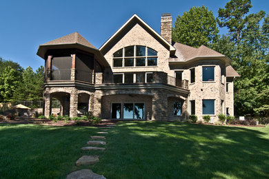 Diseño de fachada de casa beige clásica grande de dos plantas con revestimiento de ladrillo, tejado a dos aguas y tejado de teja de madera