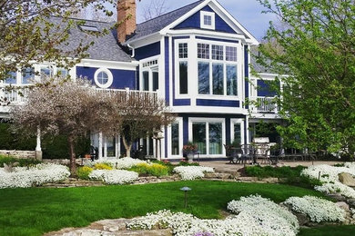 Example of a large classic blue two-story wood house exterior design in Other