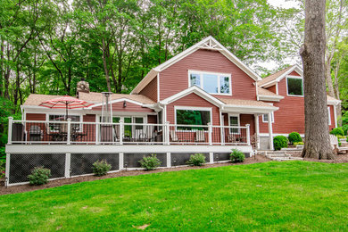 Imagen de fachada de casa roja de estilo de casa de campo de tamaño medio de dos plantas con revestimiento de madera, tejado a dos aguas y tejado de teja de madera