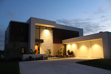 Modelo de fachada blanca minimalista grande de dos plantas con revestimientos combinados y tejado plano