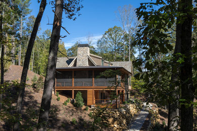 Inspiration pour une grande façade de maison marron chalet en bois à un étage avec un toit à deux pans et un toit en shingle.