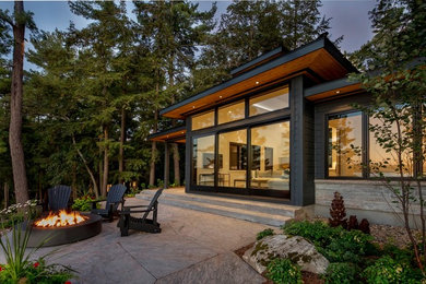 Inspiration for a mid-sized contemporary black one-story mixed siding exterior home remodel in Toronto with a shingle roof