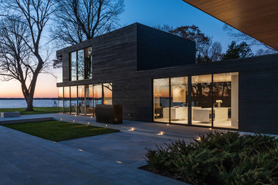 Cette photo montre une grande façade de maison moderne en bois à un étage.