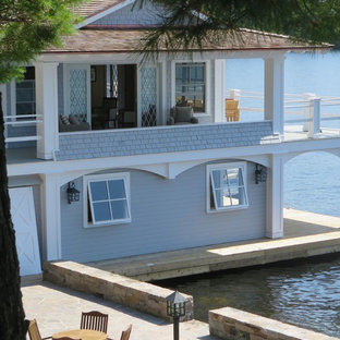Inspiration for a mid-sized beach style two-storey grey exterior in Toronto with wood siding and a hip roof.