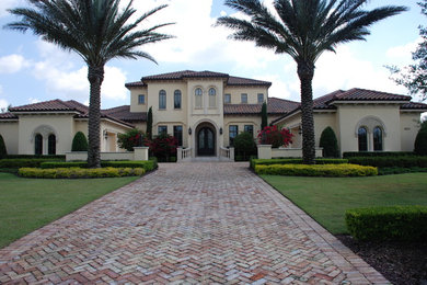Mediterranean beige two-story stucco exterior home idea in Orlando with a hip roof