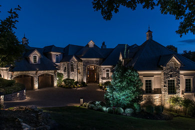 Inspiration for a huge mediterranean beige three-story stone gable roof remodel in Other