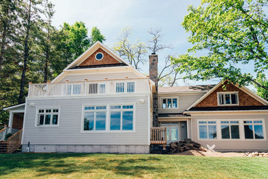 Ejemplo de fachada de casa gris de estilo americano de tamaño medio de dos plantas con revestimiento de madera, tejado a dos aguas y tejado de teja de madera