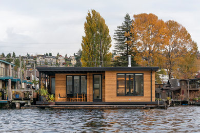 На фото: одноэтажный, деревянный дом в морском стиле с плоской крышей с