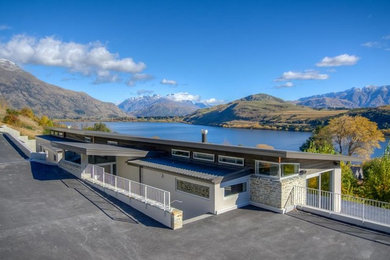 Inspiration for a large modern one-story exterior home remodel in Christchurch with a shed roof