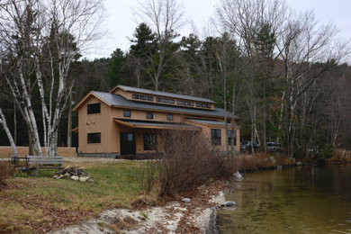 Imagen de fachada de casa beige de estilo de casa de campo pequeña de dos plantas con revestimiento de madera y tejado de metal