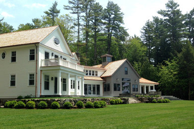 Foto de fachada de casa multicolor campestre grande de dos plantas con tejado a dos aguas, tejado de teja de madera y revestimiento de madera