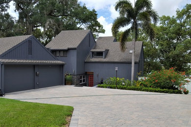 Inspiration for a mid-sized contemporary black three-story wood exterior home remodel in Orlando with a shingle roof
