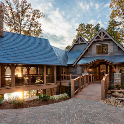 Inspiration for a large timeless brown two-story wood gable roof remodel in Other