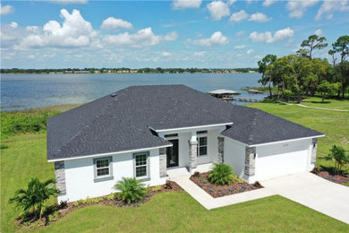 Medium sized nautical bungalow detached house in Tampa with stone cladding and a shingle roof.