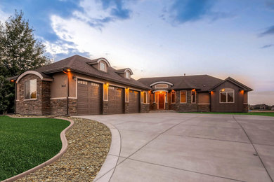 Large elegant brown one-story stucco house exterior photo in Denver with a hip roof and a shingle roof