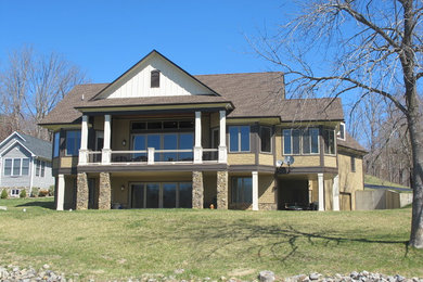Example of a mid-sized classic yellow two-story stone gable roof design in Detroit