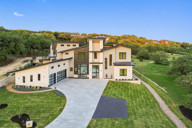 Inspiration for a large modern beige two-story mixed siding house exterior remodel in Austin with a shed roof and a metal roof