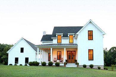 Zweistöckiges Landhausstil Einfamilienhaus mit Faserzement-Fassade, weißer Fassadenfarbe, Satteldach, Schindeldach und Dachgaube in Sonstige