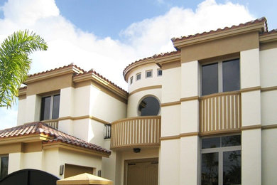 Tuscan beige two-story stucco exterior home photo in Miami