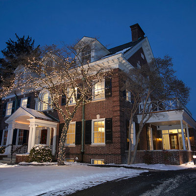 Example of a mid-sized classic red two-story brick exterior home design in Other