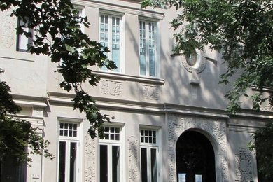 Immagine della facciata di una casa a schiera beige classica a tre piani con rivestimento in stucco