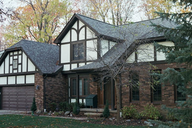 Ejemplo de fachada marrón actual de tamaño medio de dos plantas con revestimientos combinados y tejado a la holandesa