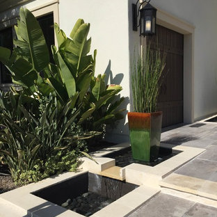 Mid-sized minimalist beige two-story stucco house exterior photo in Orange County with a tile roof