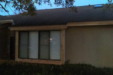 This is an example of a medium sized and beige classic bungalow render house exterior in Orlando with a hip roof.
