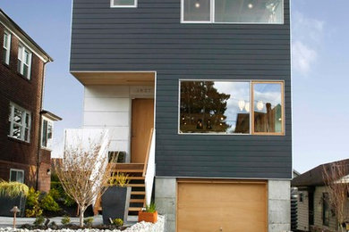 Imagen de fachada negra contemporánea de tres plantas con tejado plano