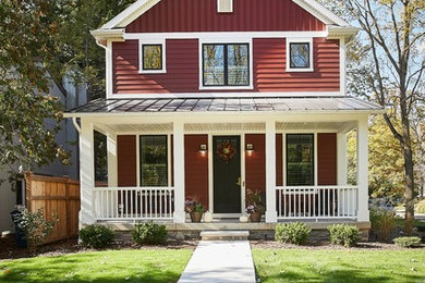 Modelo de fachada de casa roja de estilo de casa de campo de tamaño medio de dos plantas con revestimiento de aglomerado de cemento, tejado a dos aguas y tejado de metal