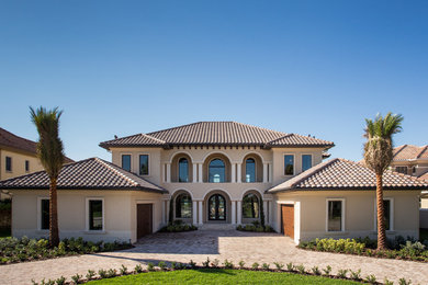 Huge mediterranean beige two-story stucco exterior home idea in Orlando