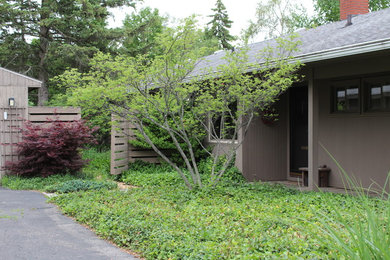 Ejemplo de fachada de casa marrón vintage de tamaño medio de una planta con revestimiento de madera, tejado a dos aguas y tejado de teja de madera