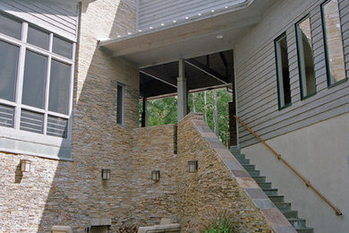 Example of a large trendy gray two-story stone flat roof design in Atlanta
