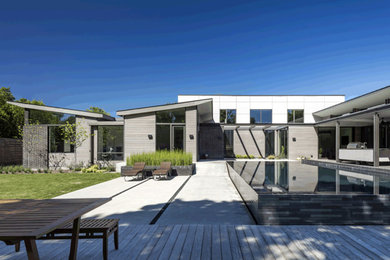 Inspiration för mycket stora moderna grå hus, med två våningar, tegel, pulpettak och tak i metall