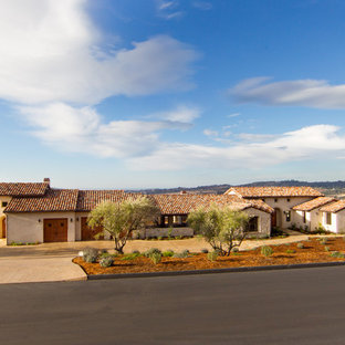 Example of a mid-sized tuscan beige one-story stucco gable roof design in San Luis Obispo