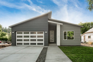 Cette image montre une façade de maison grise design de plain-pied avec un revêtement mixte.