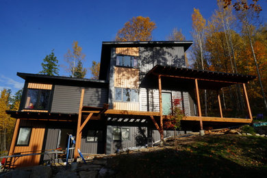 Imagen de fachada gris de dos plantas con revestimiento de metal y tejado de un solo tendido