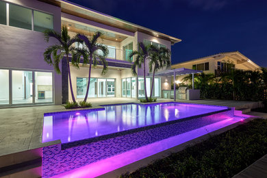 Trendy two-story house exterior photo in Miami with a metal roof
