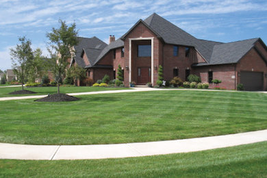 Example of a classic two-story brick exterior home design in Cleveland