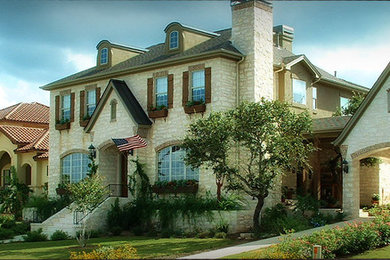 Example of a large beige two-story stone exterior home design in Austin