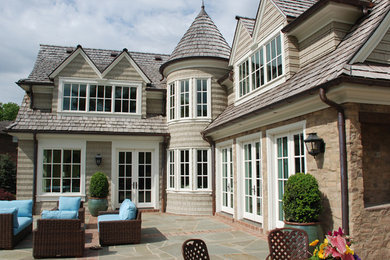 Imagen de fachada de casa beige clásica grande de dos plantas con revestimientos combinados, tejado a dos aguas y tejado de teja de madera