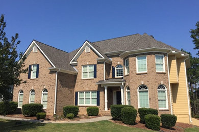Large traditional beige two-story brick house exterior idea in Atlanta with a hip roof and a shingle roof