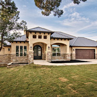 Example of a tuscan stone exterior home design in Austin with a metal roof